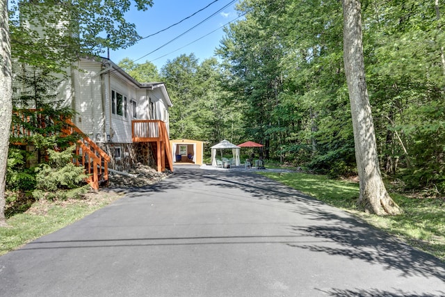 view of street with aphalt driveway and stairway