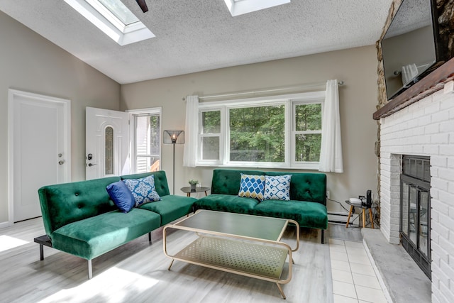 living room featuring lofted ceiling with skylight, baseboard heating, a brick fireplace, and wood finished floors