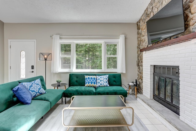 tiled living area with a brick fireplace and a textured ceiling