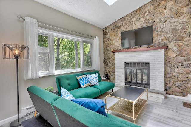 living room with baseboards, wood finished floors, vaulted ceiling, a textured ceiling, and a fireplace