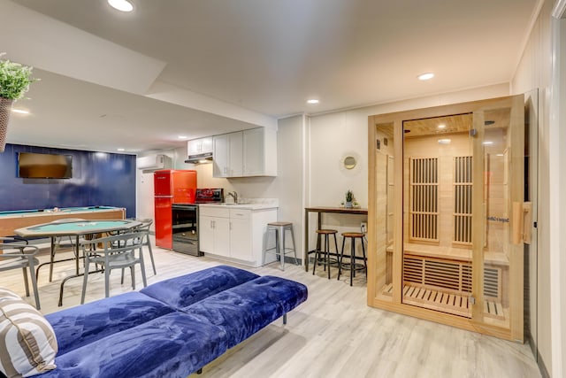 living area with a sauna, recessed lighting, and light wood-style floors