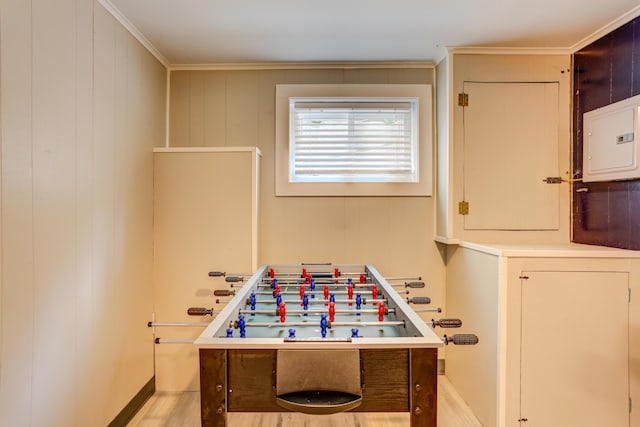 playroom featuring light wood-type flooring, electric panel, and crown molding