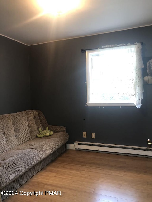 interior space with wood finished floors and a baseboard radiator