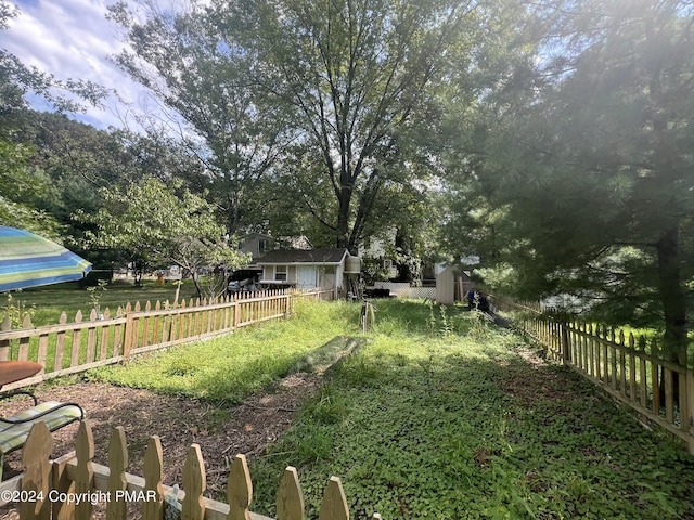 view of yard with an outbuilding, a storage shed, and a fenced backyard