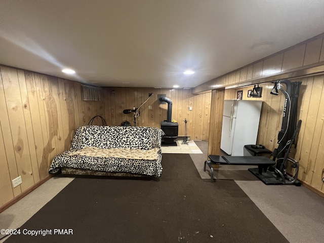 exercise room featuring a wood stove, recessed lighting, and wood walls