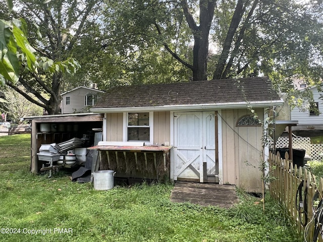 back of house with an outbuilding and a yard