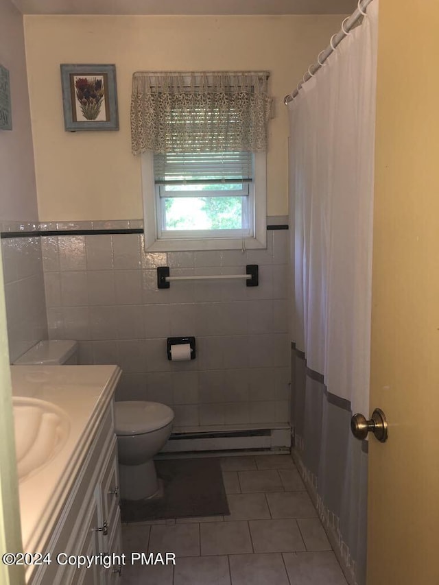 bathroom featuring tile patterned floors, a baseboard radiator, toilet, and tile walls