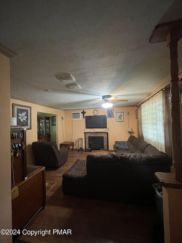 living area with a textured ceiling, a wall unit AC, a fireplace, and ceiling fan