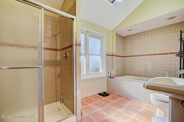 full bath with tile patterned floors, a garden tub, vaulted ceiling, a shower stall, and tile walls