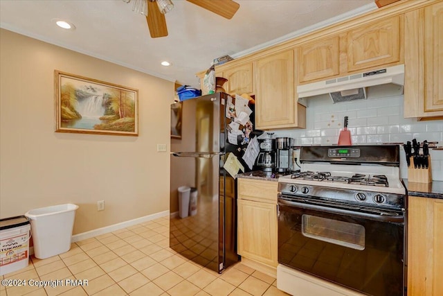 kitchen featuring tasteful backsplash, freestanding refrigerator, light brown cabinetry, under cabinet range hood, and gas stove