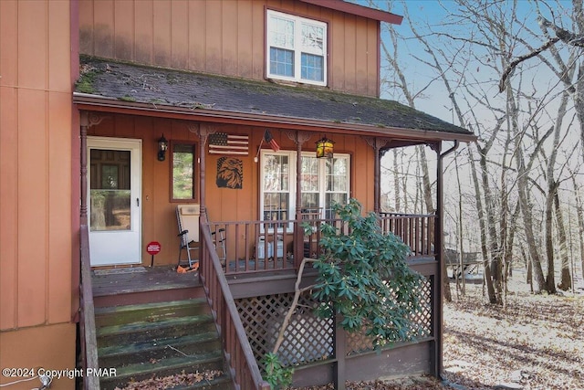 view of front of property with covered porch, roof with shingles, and board and batten siding