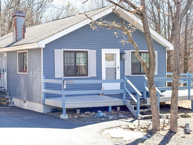 view of front of property featuring a chimney and a shingled roof