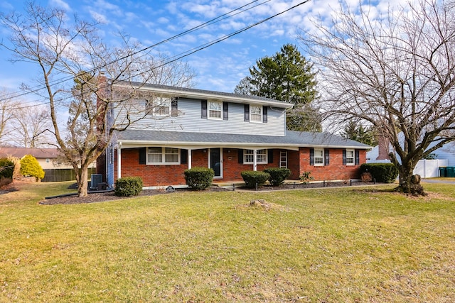 view of front facade featuring brick siding, a front yard, and fence