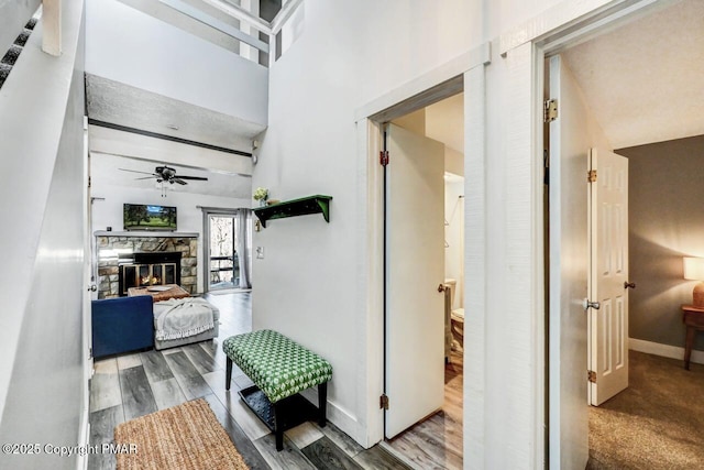 corridor featuring wood-type flooring and a high ceiling