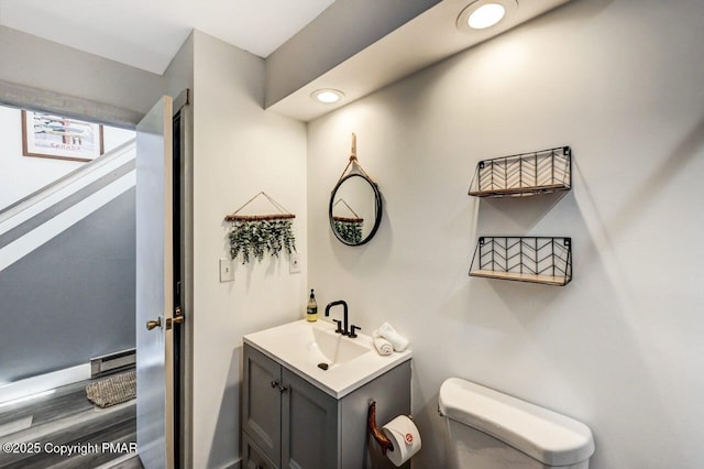 bathroom with vanity, toilet, and baseboard heating