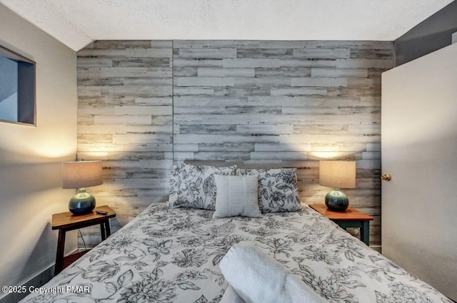 bedroom with wooden walls and a textured ceiling