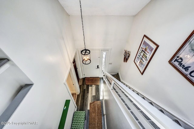 stairway featuring hardwood / wood-style floors, a notable chandelier, and a towering ceiling