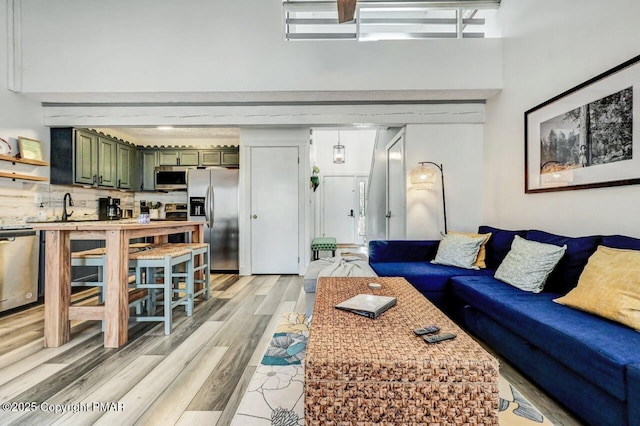 living room featuring a towering ceiling and light hardwood / wood-style floors