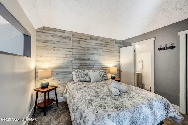 bedroom featuring dark carpet, a textured ceiling, and wood walls