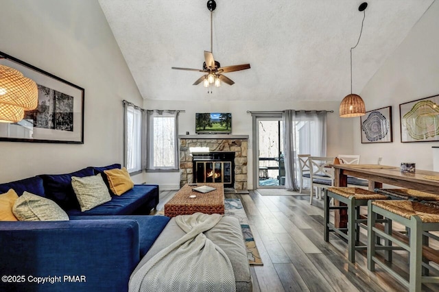 living room featuring hardwood / wood-style flooring, a wealth of natural light, a textured ceiling, and a fireplace