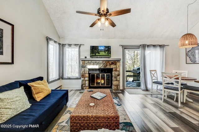 living room featuring wood-type flooring, vaulted ceiling, a textured ceiling, and a wealth of natural light