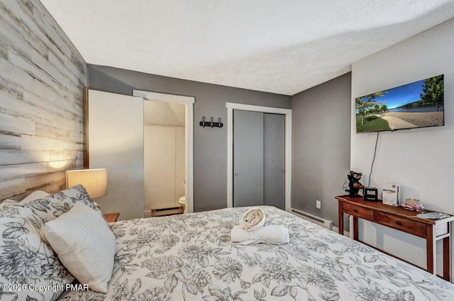 bedroom featuring a baseboard radiator and a closet