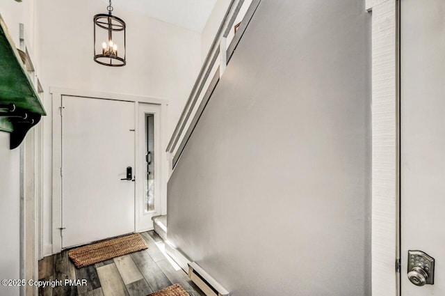 foyer entrance with a notable chandelier, hardwood / wood-style flooring, and a baseboard heating unit