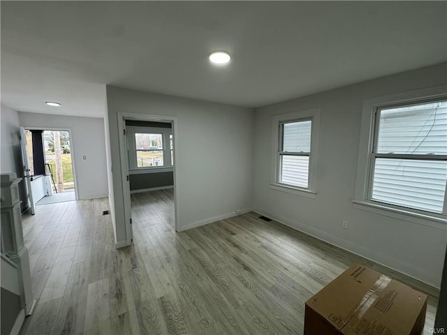 unfurnished room with baseboards, light wood-style floors, and visible vents