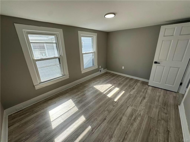 unfurnished bedroom with baseboards, visible vents, and wood finished floors