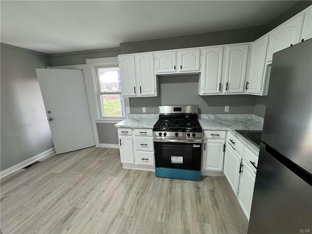 kitchen featuring white cabinetry, light wood-style flooring, appliances with stainless steel finishes, and baseboards