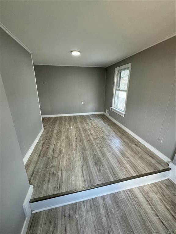 empty room featuring baseboards and wood finished floors