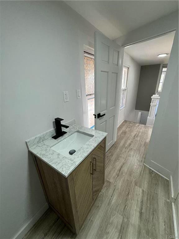 bathroom featuring baseboards, wood finished floors, and vanity