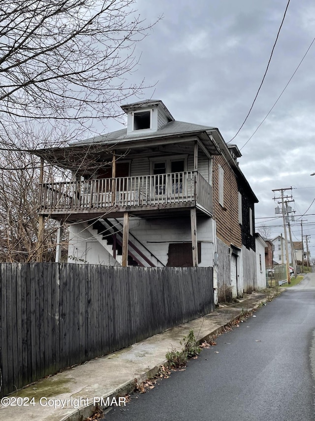 view of property exterior featuring fence and stairs