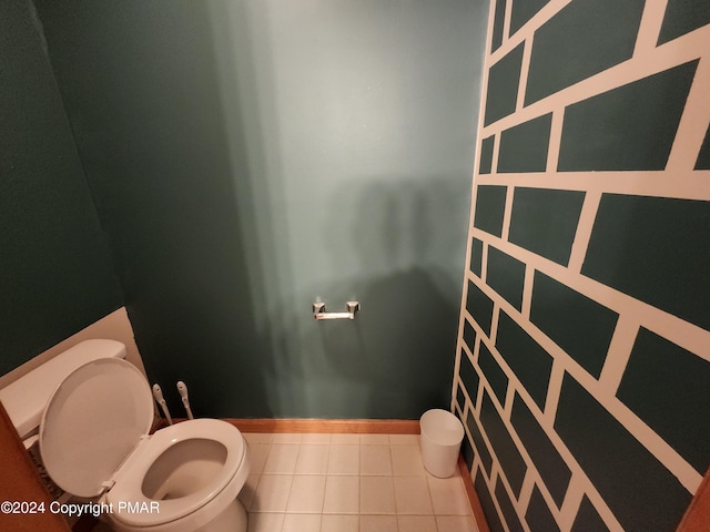 bathroom with baseboards, toilet, and tile patterned flooring