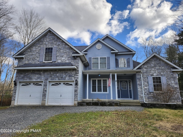 traditional home featuring stone siding, driveway, covered porch, and an attached garage