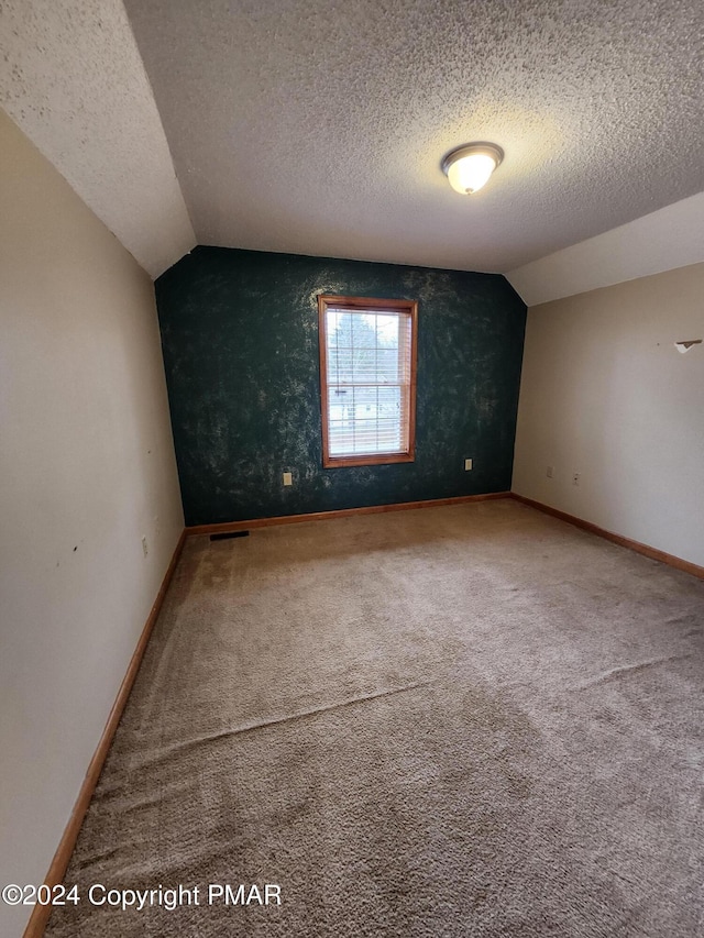 bonus room featuring vaulted ceiling, baseboards, carpet floors, and a textured ceiling