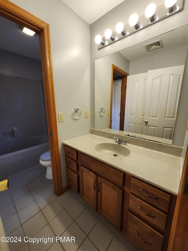 bathroom with vanity, visible vents, tile patterned flooring, a textured ceiling, and toilet