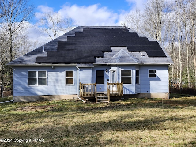 rear view of property featuring a wooden deck and a yard