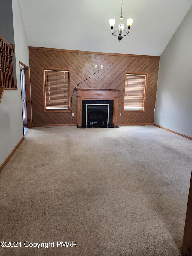 unfurnished living room with wooden walls, a fireplace, high vaulted ceiling, and carpet