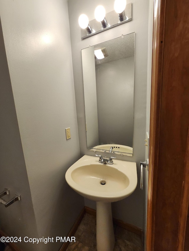 bathroom featuring baseboards and a sink