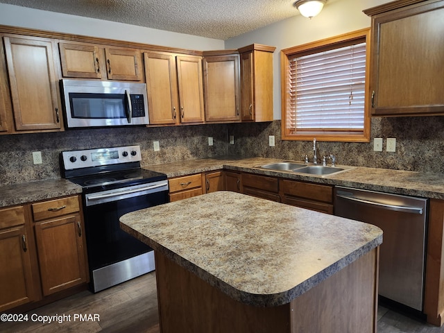 kitchen featuring a sink, tasteful backsplash, a textured ceiling, appliances with stainless steel finishes, and dark wood-style flooring