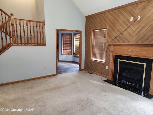 unfurnished living room featuring baseboards, visible vents, carpet floors, high vaulted ceiling, and a tiled fireplace