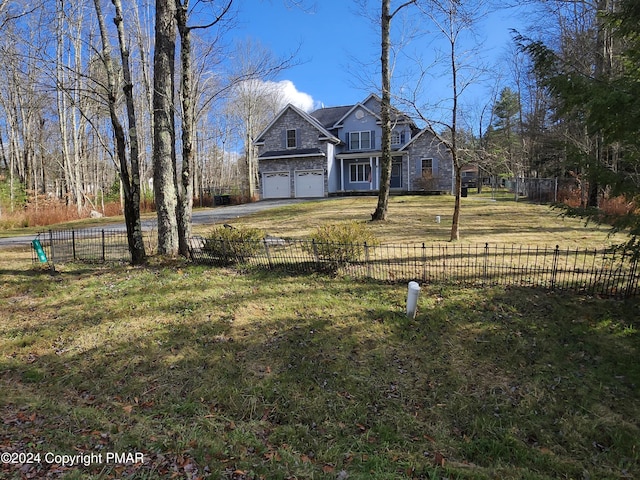 view of front of home featuring driveway, a front lawn, a garage, and fence