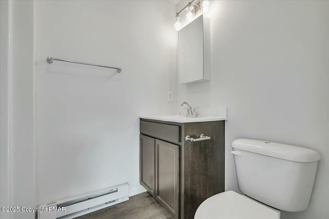 bathroom with toilet, a baseboard radiator, wood finished floors, and vanity