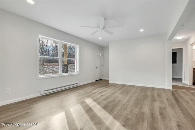 spare room with baseboards, baseboard heating, and light wood-style floors