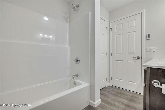 full bath featuring  shower combination, wood finished floors, and vanity