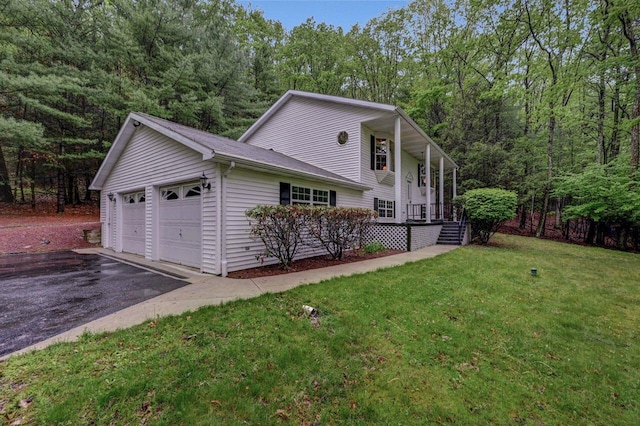 view of side of property featuring a lawn and a garage