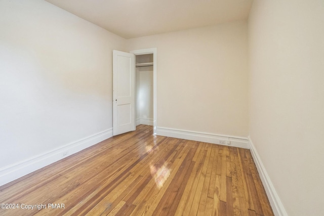 spare room featuring light wood finished floors and baseboards