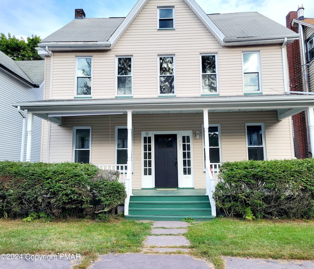 view of front of property featuring a chimney and a porch