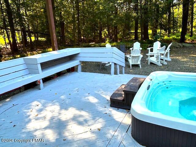 wooden terrace featuring an outdoor hot tub